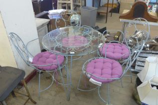 A painted wrought alloy and glass topped garden table and four chairs