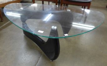An Isama Noguchi style black metal and glass topped coffee table