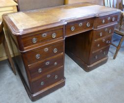 A Victorian mahogany and tan leather topped breakfront pedestal desk