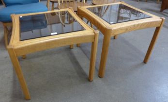 A pair of Ercol elm and glass topped occasional tables