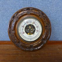 An early 20th Century circular carved walnut aneroid barometer, the dial signed Chadburns Ltd., 47