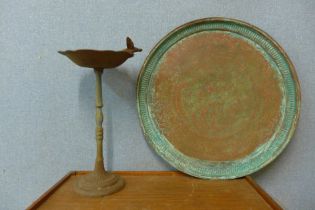 A small cast iron bird bath and a copper charger
