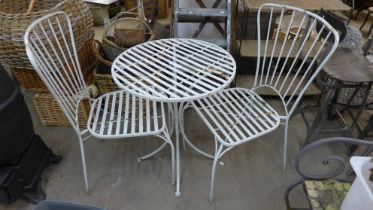 A painted wrought alloy garden table and two chairs