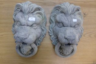 A pair of concrete garden wall hanging lion masks