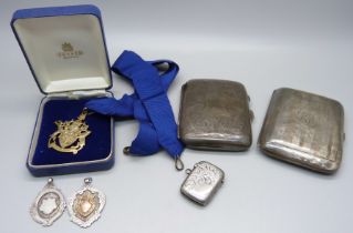 Two silver cigarette cases, two silver fob medals, a silver vesta case and a silver Freeman