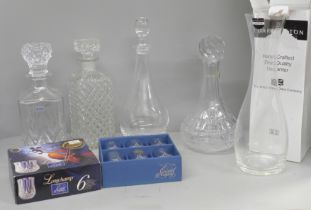 A collection of crystal and glass decanters, including a boxed set of drinking glasses and