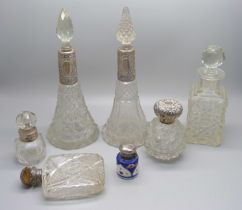 A collection of five cut glass scent bottles with silver tops/collars, a small porcelain silver