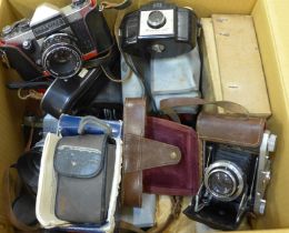 A box of mixed film cameras and accessories