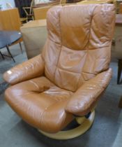 A Norweigan Ekorness beech and tan leather revolving lounge chair