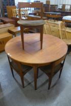 A Nathan teak circular extending dining table and four chairs