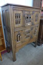 An Elizabethan Revival carved oak two door livery cupboard