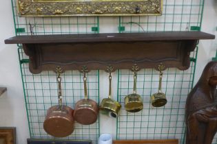 A French oak wall hanging saucepan rack, with copper and brass pans