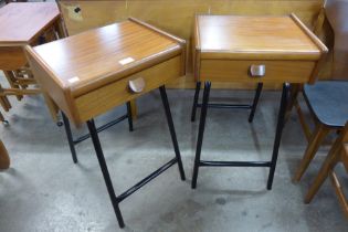 A pair of teak bedside cabinets, on black tubular metal stands