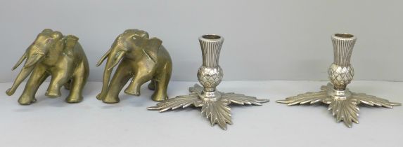 A pair of plated thistle candlesticks and two brass model elephants