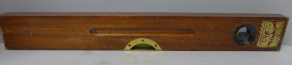 A Rabone & Sons spirit level, with tin