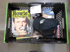 Two boxes of music related memorabilia including David Bowie merchandise, baseball caps, sweat