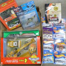 A collection of boxed model vehicles including Hot Wheels cars and a 4-Piece Construction Set