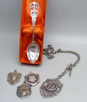 Three silver fob medals including one cricket and one boxing, a silver watch chain and a golf spoon,