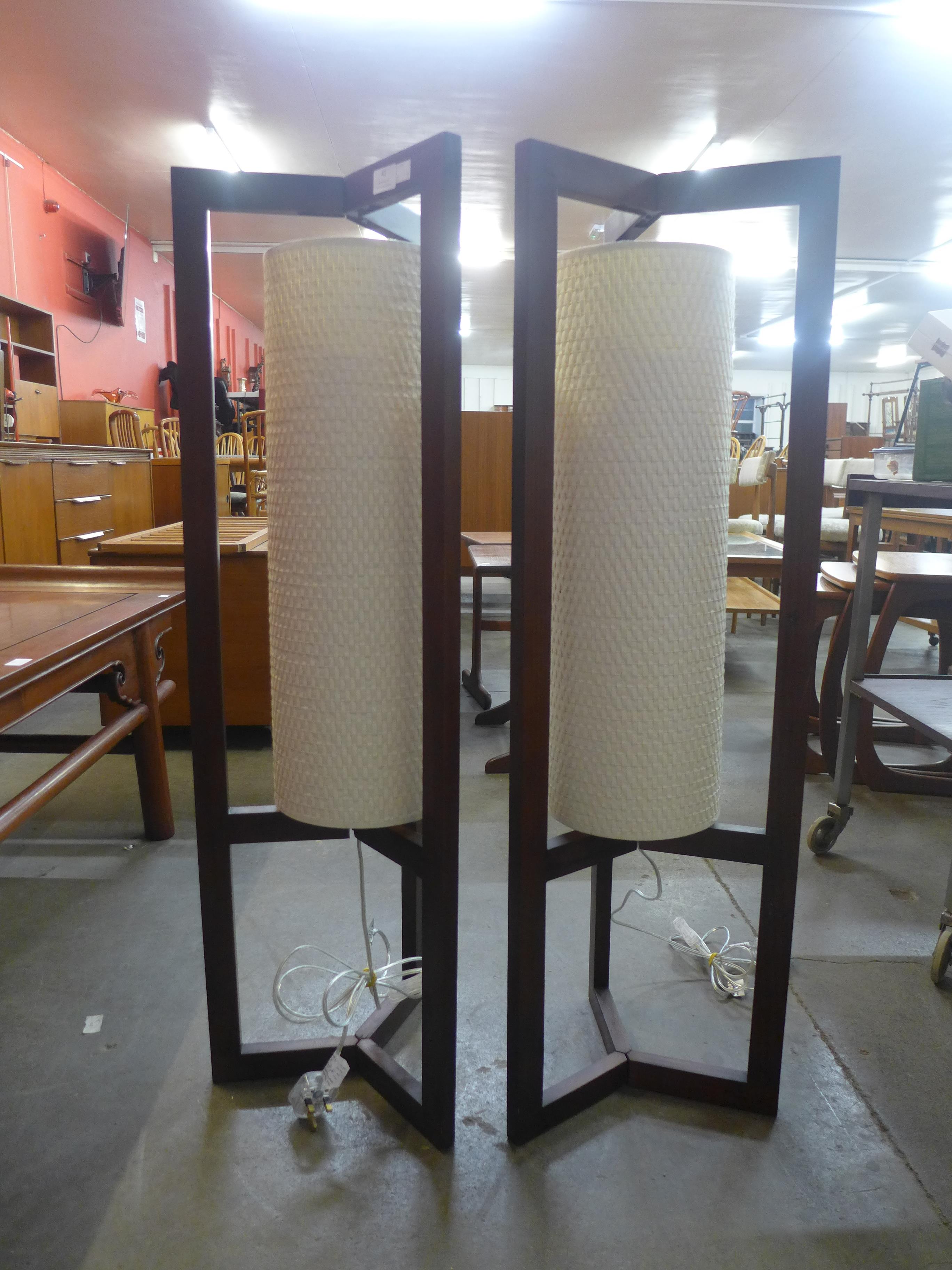 A pair of teak effect floor standing lamps