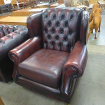 A Thames Lloyd burgundy leather Chesterfield wingback armchair