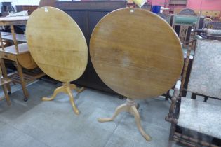 A pair of George III style oak circular tilt-top tripod tea tables