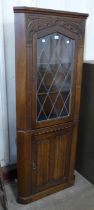 A carved oak linenfold freestanding corner cabinet