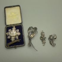 Three silver brooches and a silver conductors fob medal, 71g