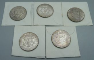 Five 1964 American silver half dollar coins