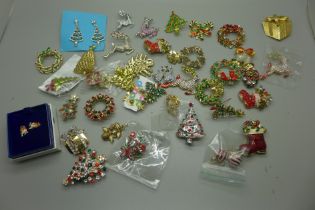 A collection of Christmas themed brooches and earrings