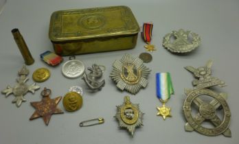 A WWI Christmas tin containing military badges and medals