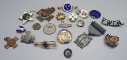 A collection of military pin badges and other badges including enamel