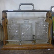 An early 20th Century oak and brass mounted tantalus (locked and decanters lacking stoppers)