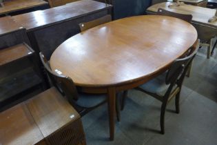 A teak extending dining table and a set four walnut dining chairs