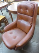 A chrome and burgundy vinyl revolving lounge chair