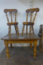 A Victorian style doll's elm kitchen table and two chairs