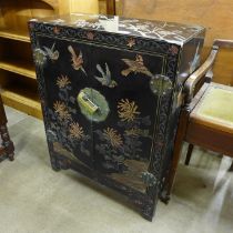 A Chinese black lacquered chinoiserie two door cabinet
