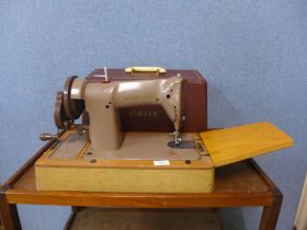 A cased Singer sewing machine, with accessories