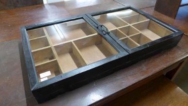 A black painted wall hanging two door display cabinet