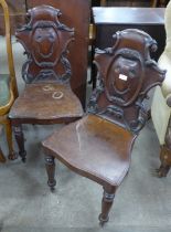 A pair of Victorian carved mahogany hall chairs