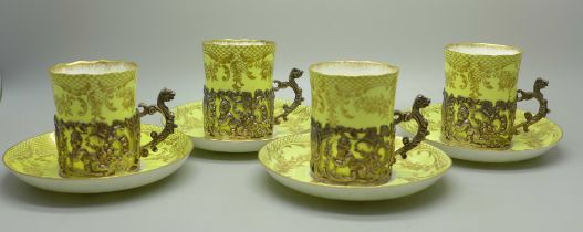 Four Staffordshire 'Eggshell' coffee cans and saucers with four silver holders, William Comyns,