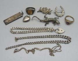 A collection of silver jewellery including a 1977 ingot, a lizard brooch, two rings, a curb chain