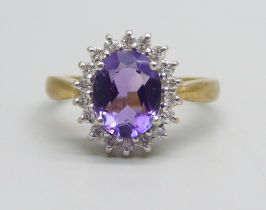 An 18ct gold ring set with an amethyst and diamond halo, 4.5g, Q