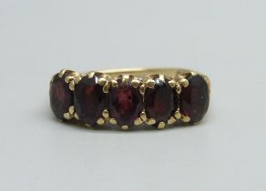 A 9ct gold ring set with five garnets, 2.7g, O