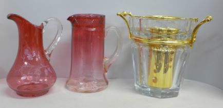 A crystal ice bucket/wine cooler and two cranberry glass jugs **PLEASE NOTE THIS LOT IS NOT ELIGIBLE