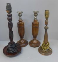 A pair of wooden candlesticks and two table lamp bases; one brass, the other barleytwist