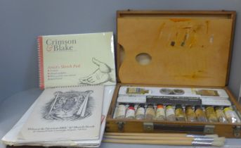 A Rowney wooden artist's case with paints, palette, brushes and sketch pads