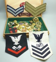 A collection of military items including patches, buttons and cap badges