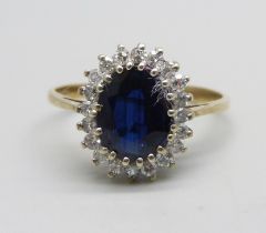 A 9ct gold ring set with a central sapphire and diamond halo, 2.7g, Q