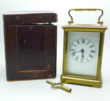 A French gilt brass and four glass sided carriage clock in leather travel case