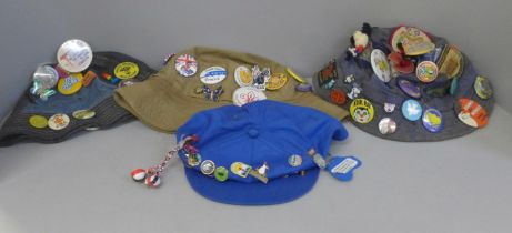 Four hats with Scout/Girl Guide and other badges